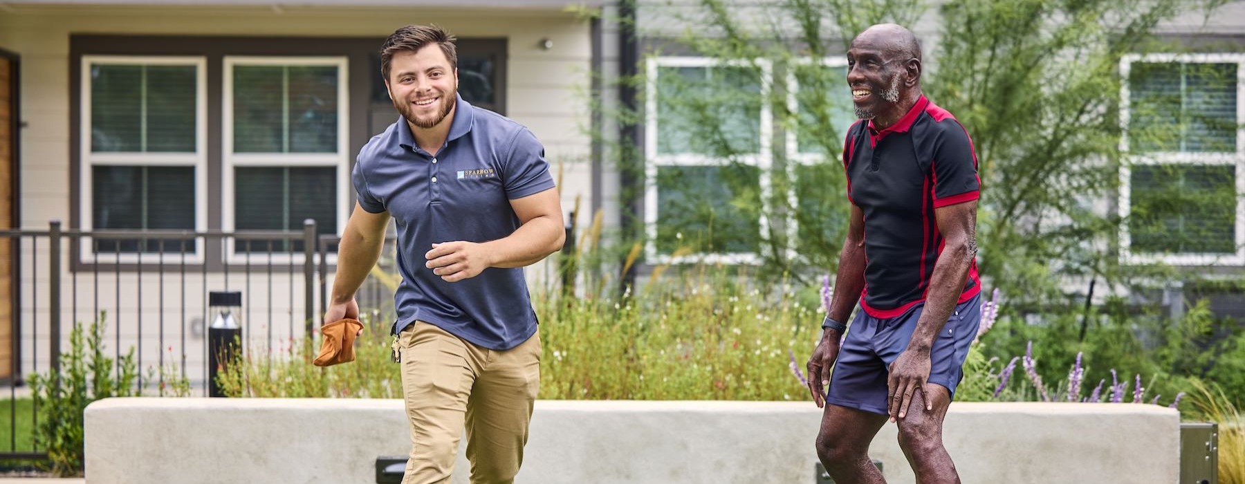 a couple of men playing cornhole